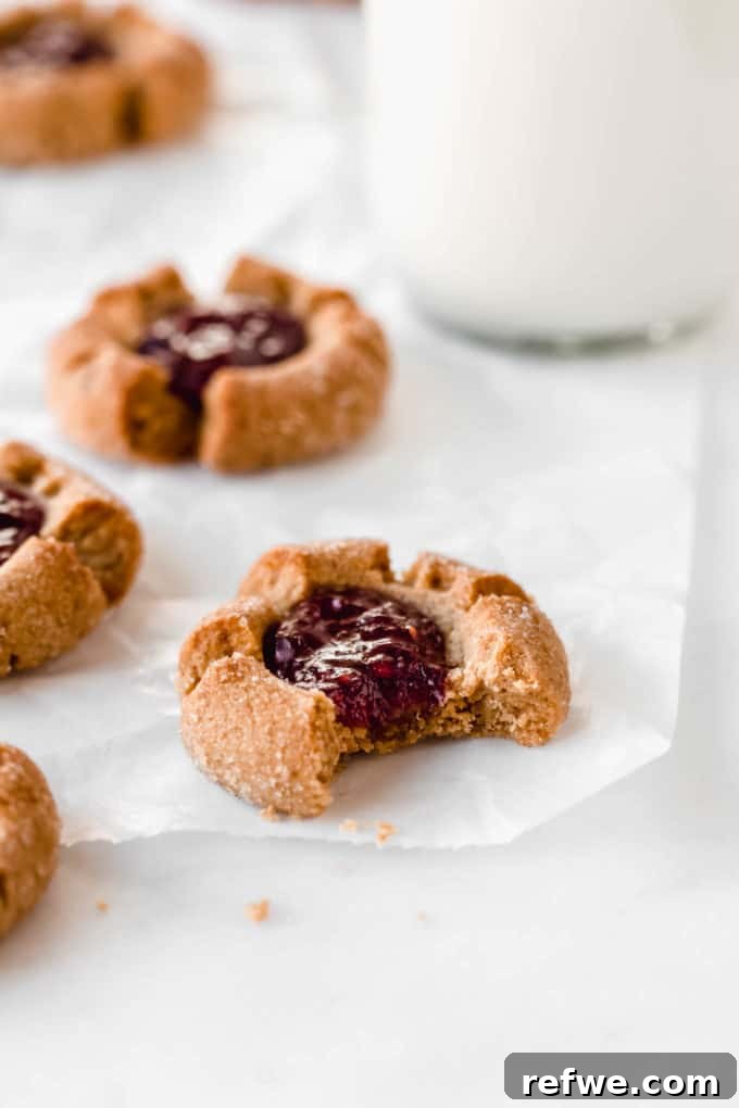 Festive & Fit: 18 Healthier Holiday Treats 8 Gluten-free Peanut Butter and Jelly Thumbprint Cookies, filled with vibrant raspberry jam, a quick and healthy holiday cookie recipe.