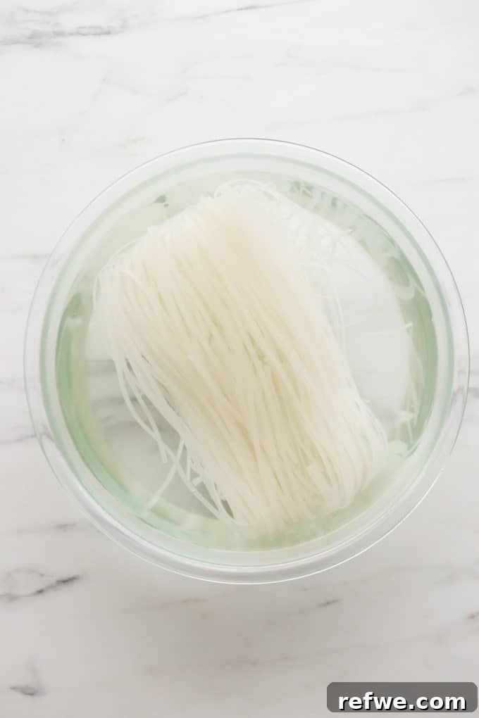 Spicy Thai Red Curry Noodles 4 Rice noodles soaking in water in a clear bowl