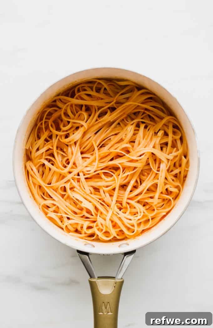 Spicy Thai Red Curry Noodles 8 Curry sauce and softened noodles combined in a white pan