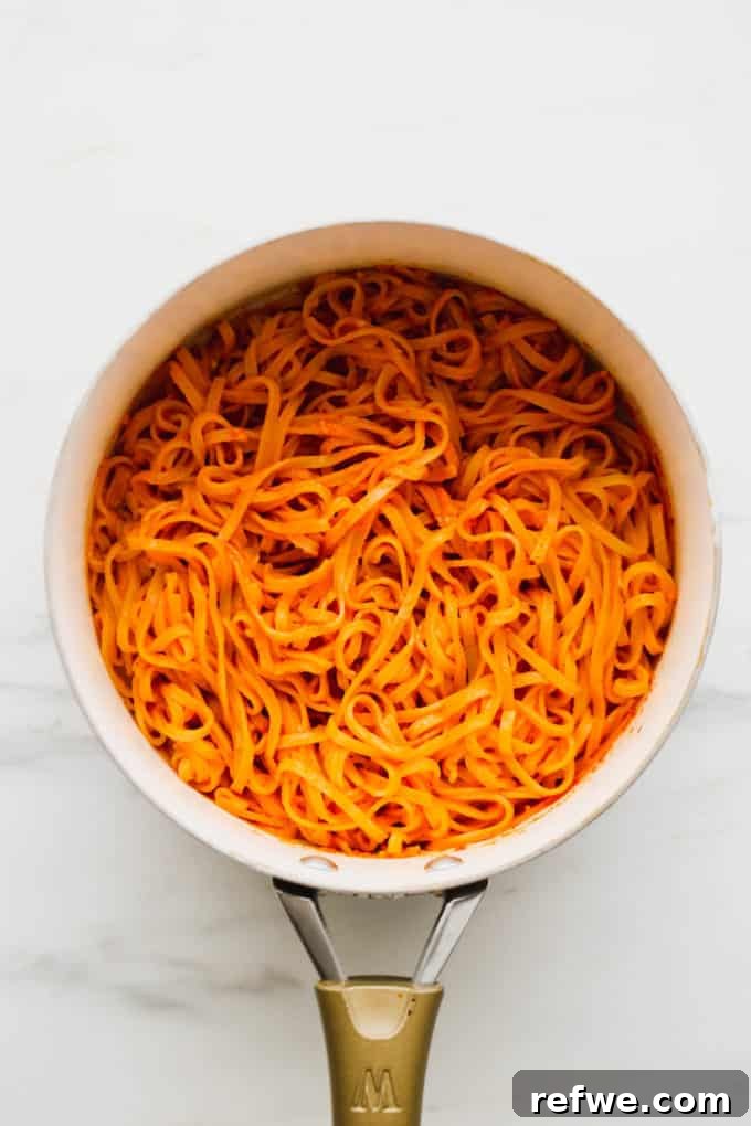 Spicy Thai Red Curry Noodles 9 Thai Red Curry Noodles cooking in a white pot, absorbing the sauce