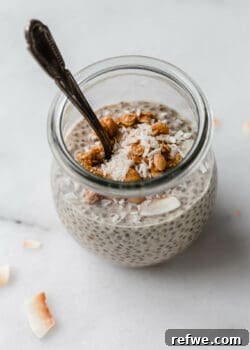 A jar of peanut butter chia pudding topped with shredded coconut and granola