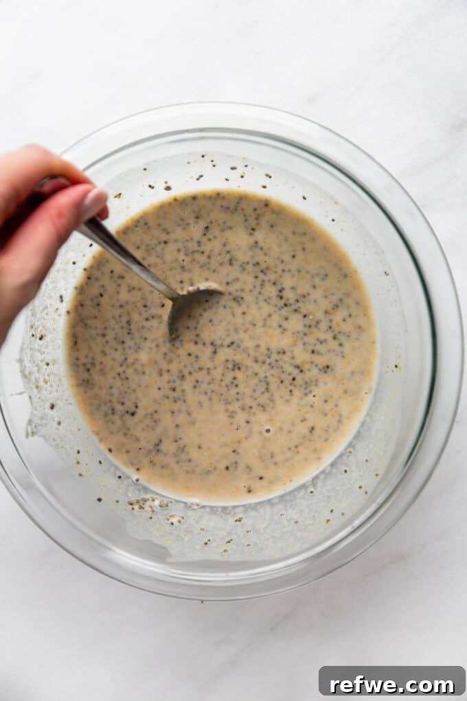 Creamy Peanut Butter Chia Pudding 5 Almond milk, chia seeds, and peanut butter thoroughly mixed together in a bowl, creating a smooth mixture for pudding.