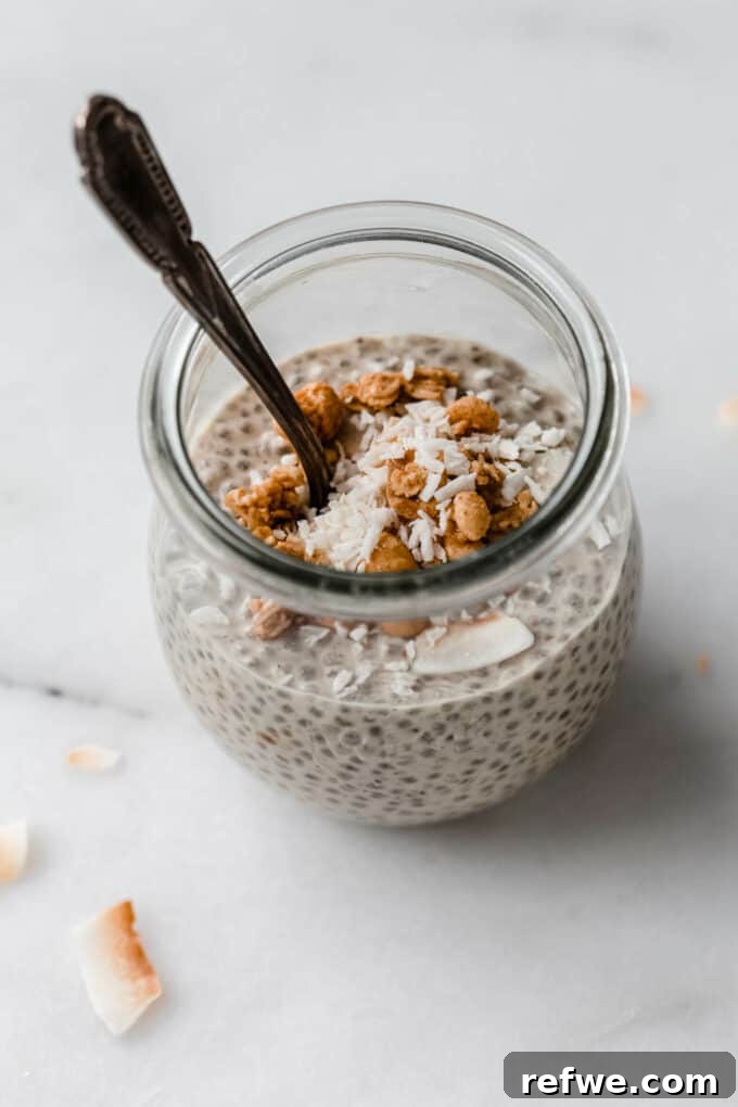 Creamy Peanut Butter Chia Pudding 7 A jar of peanut butter chia pudding topped with shredded coconut and granola, ready to be enjoyed.