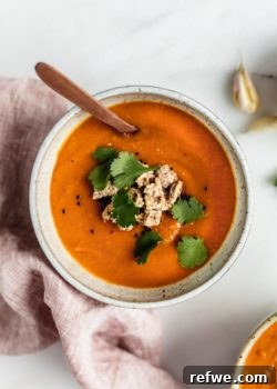 A bowl of carrot, lentil and sweet potato soup with Ryvita crisp breads crumbled on top