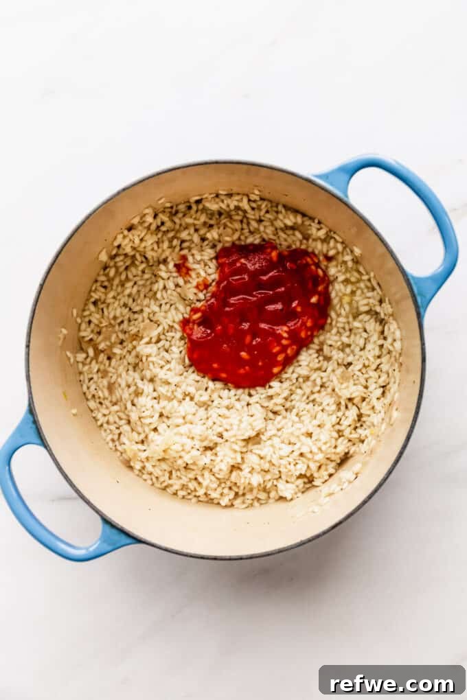 Romantic Tomato Risotto for Two 7 Arborio rice simmering with strained tomatoes in a blue pot