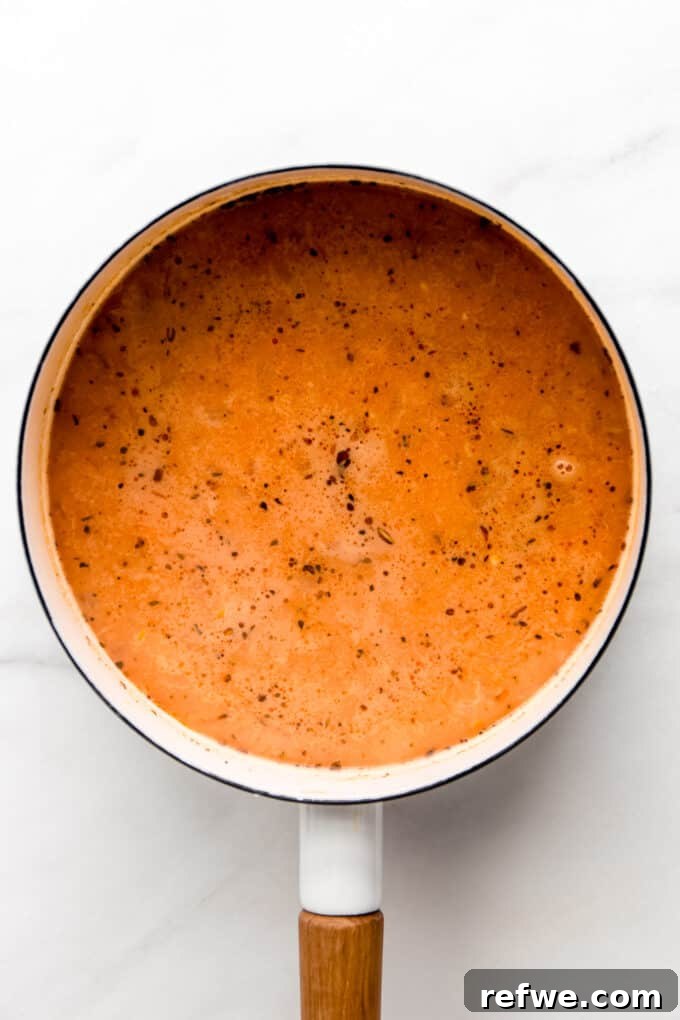 Creamy white bean soup broth after partial blending, showing a rich, smooth texture beautifully integrated.