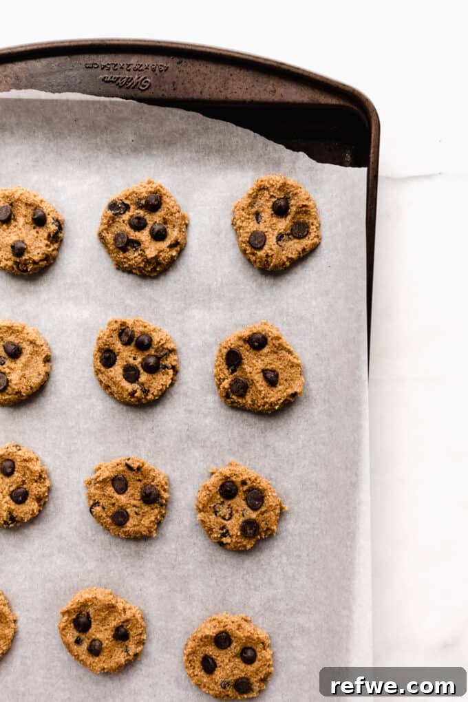 unbaked almond flour cookies scooped onto a baking sheet lined with parchment paper