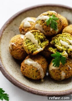 falafel on a ceramic plate drizzled with tahini