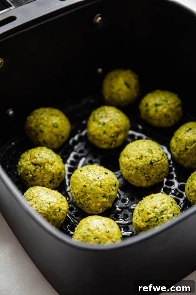 Crispy Air Fryer Falafel 7 uncooked falafel in an air fryer basket