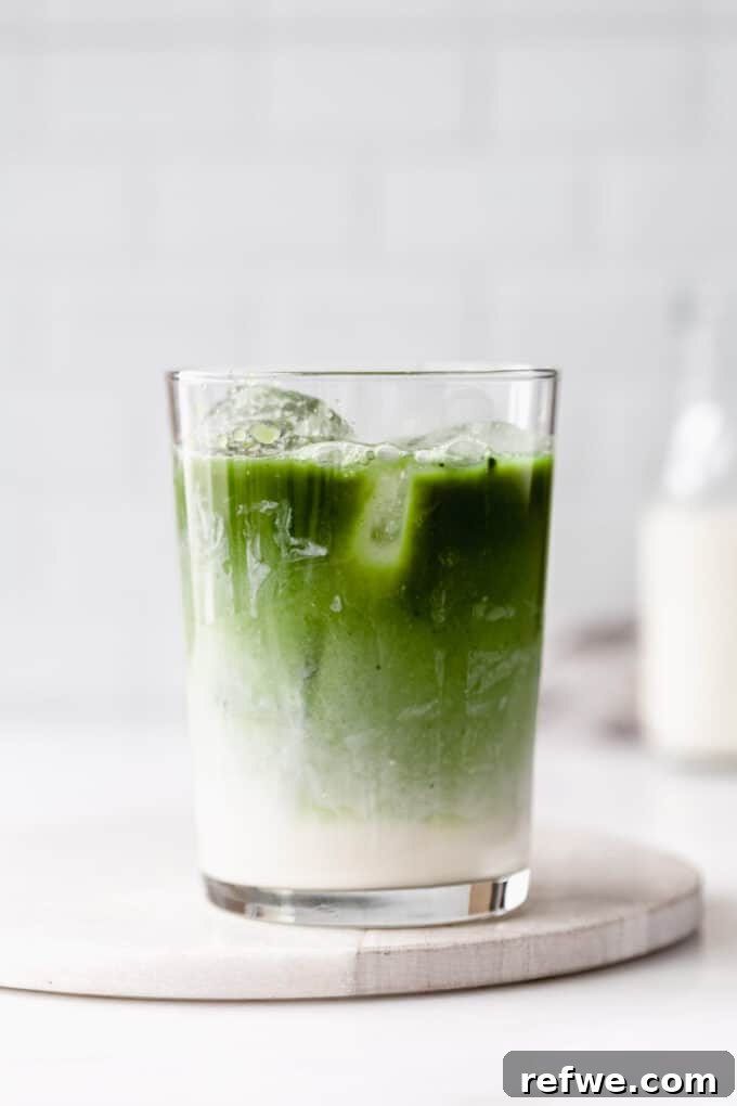 Zen Matcha Chill 6 A beautifully presented glass of iced matcha latte on a elegant marble board, garnished slightly and ready to be enjoyed.