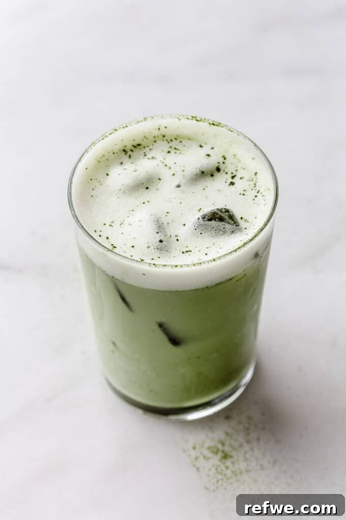 Zen Matcha Chill 7 A close-up shot of an iced matcha latte in a clear glass, showcasing its layers and refreshing appeal on a textured surface.