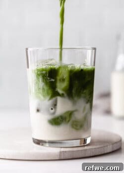 matcha being poured into a glass of oat milk