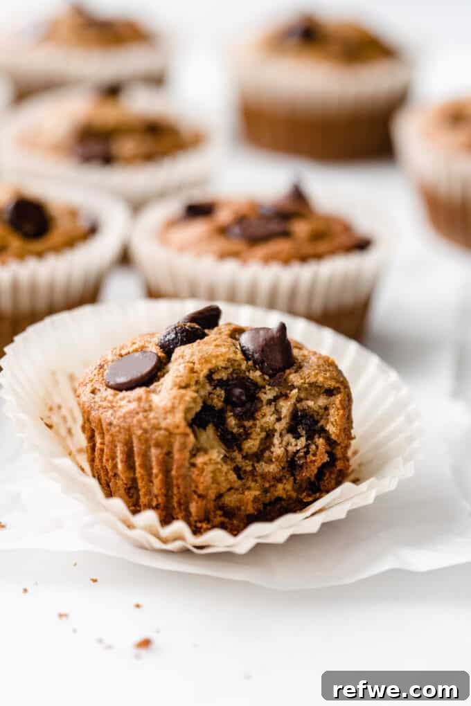 Wholesome Banana Oat Muffins 13 A baked banana oat flour muffin with a bite taken out, showing its moist and tender interior.
