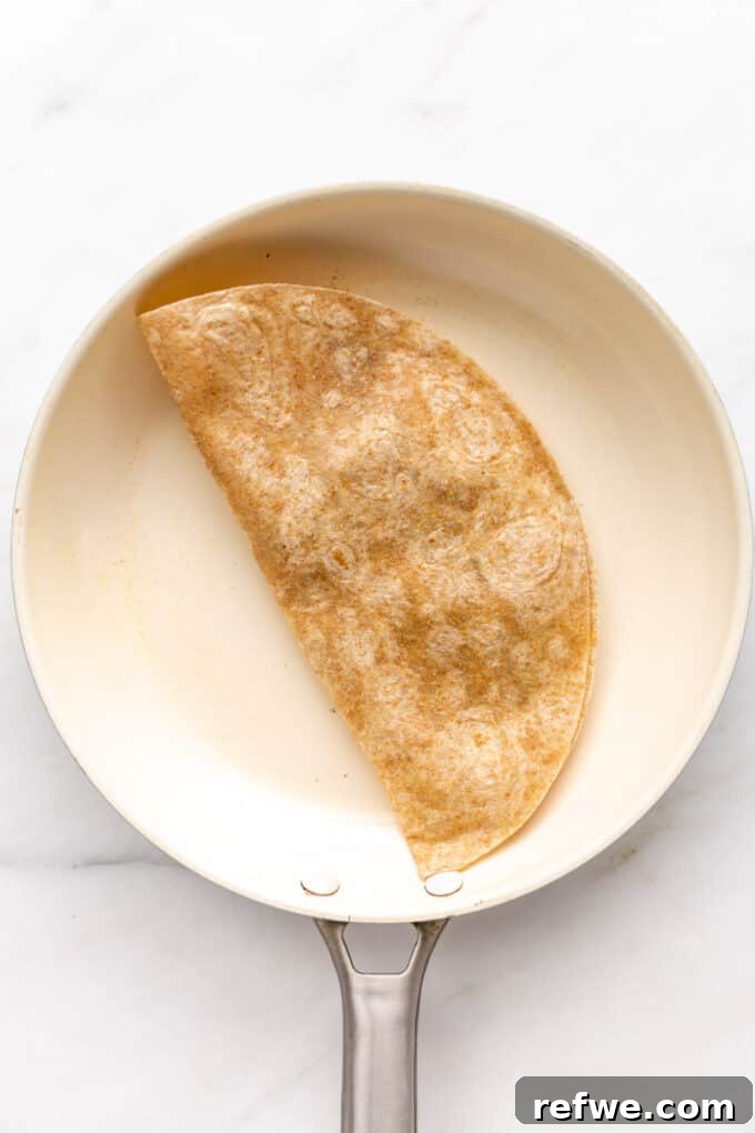 Fiesta Black Bean and Corn Quesadillas 8 A tortilla folded in half in a pan, cooking to golden brown.