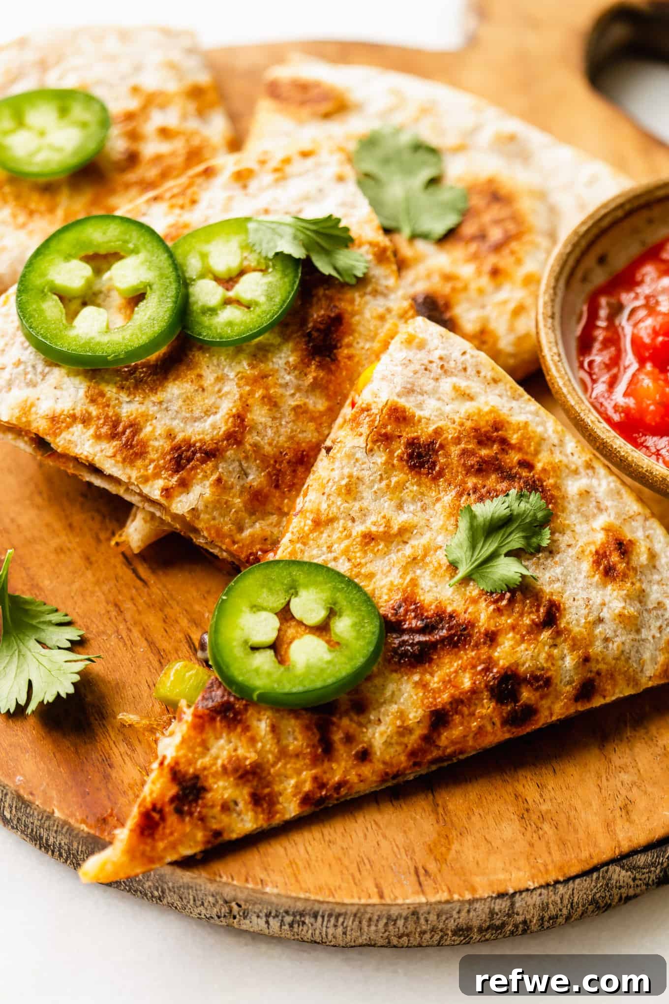 Fiesta Black Bean and Corn Quesadillas 10 Two black bean and corn quesadillas garnished with sliced jalapeño and fresh cilantro, ready to serve.