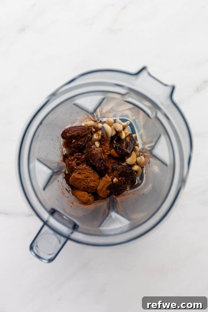 Soaked cashews, pitted Medjool dates, and cocoa powder carefully placed into a high-speed blender, ready for blending.