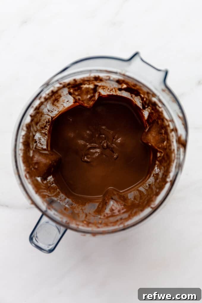 The smooth and creamy vegan chocolate pudding actively blending in a high-speed blender, demonstrating its transformation into a decadent dessert.