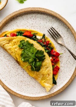 a chickpea flour omlette stuffed with peppers and spinach on a ceramic plate