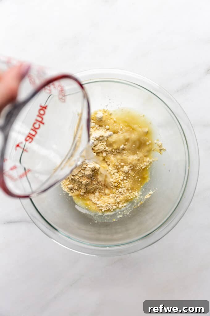 water being poured into a bowl of chickpea flour