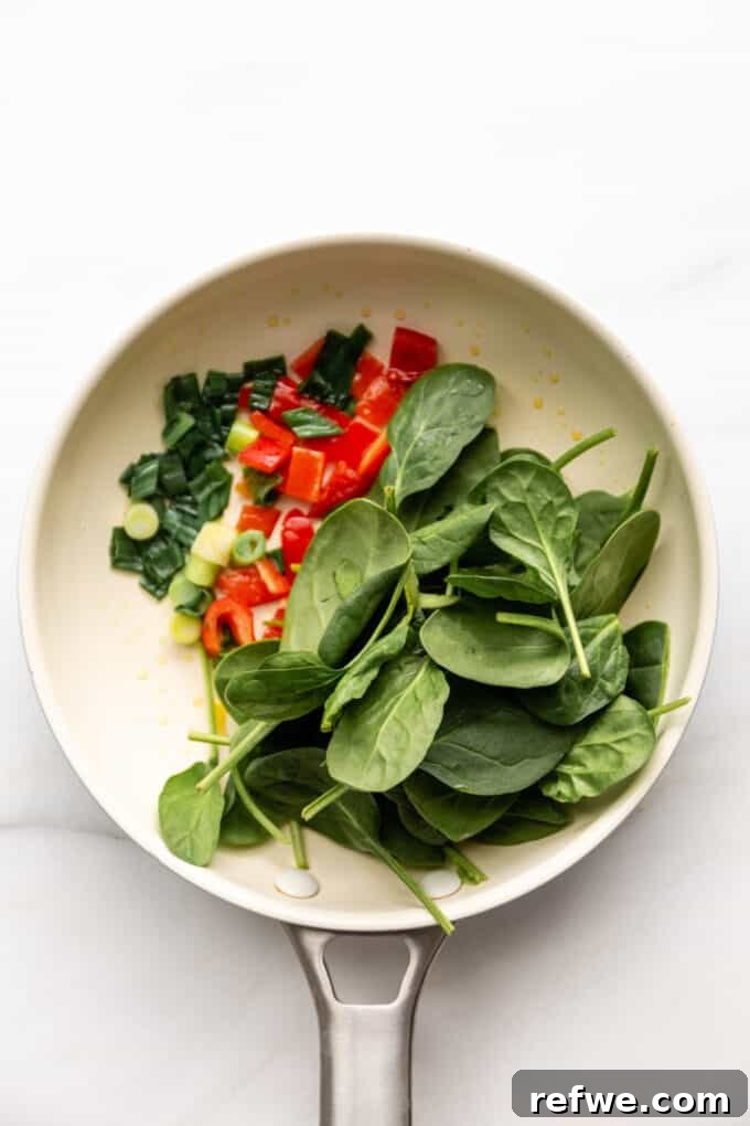 spinach, peppers and green onion in a pan