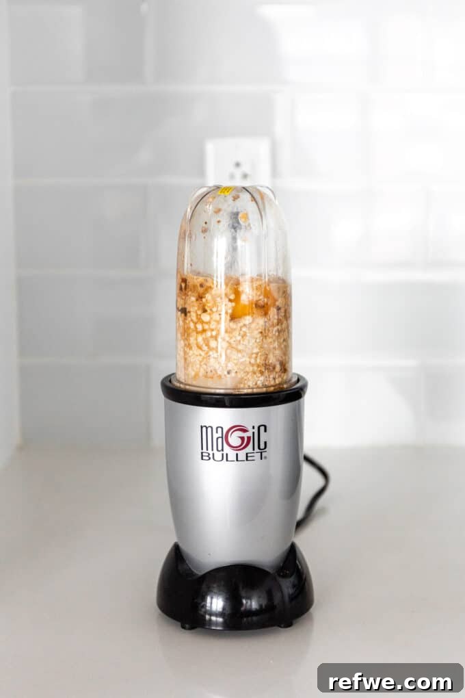 Cookie Dough Baked Oatmeal 4 All ingredients for cookie baked oatmeal, except chocolate chips, being added to a blender for mixing