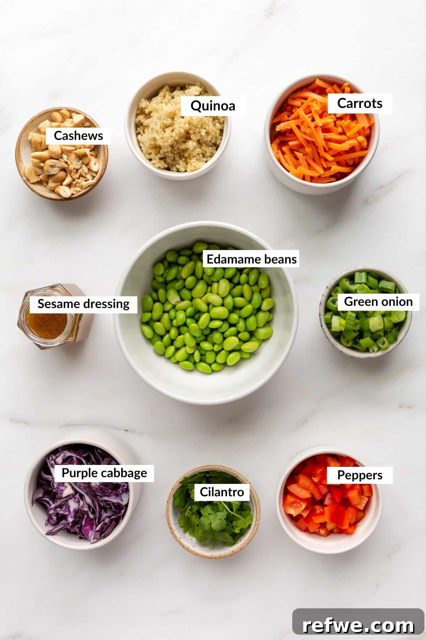 Wholesome Quinoa Edamame Crunch Bowl 3 Ingredients for edamame salad laid out, including edamame, quinoa, bell pepper, carrots, and cashews