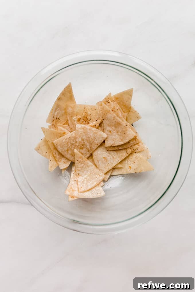 Golden Crisp Air Fryer Tortilla Chips 4 sliced tortilla chips in a clear mixing bowl