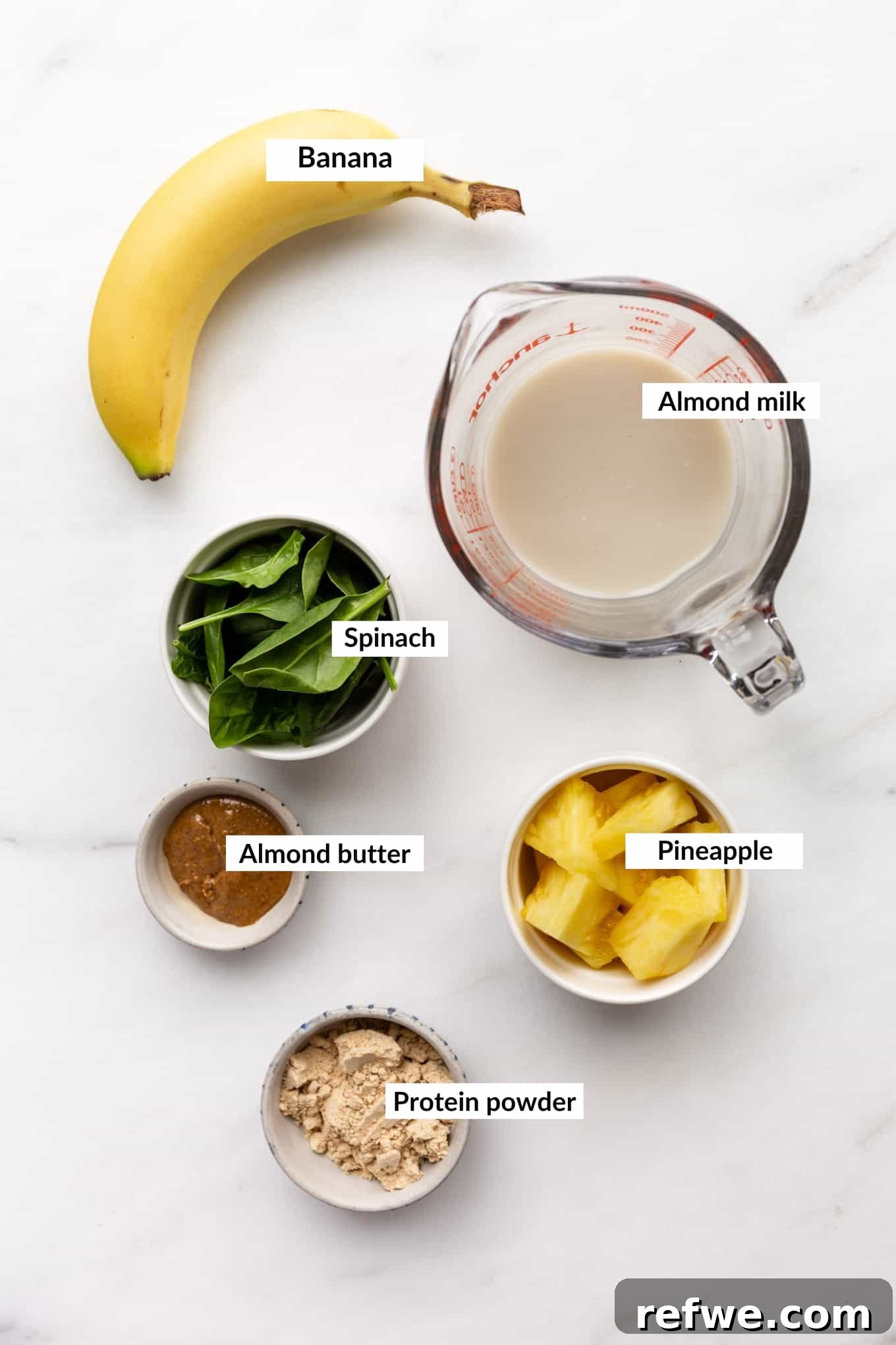 Supercharged Green Protein Smoothie 3 All the fresh ingredients for a green protein smoothie laid out: spinach, banana, pineapple, almond milk, almond butter, and protein powder.