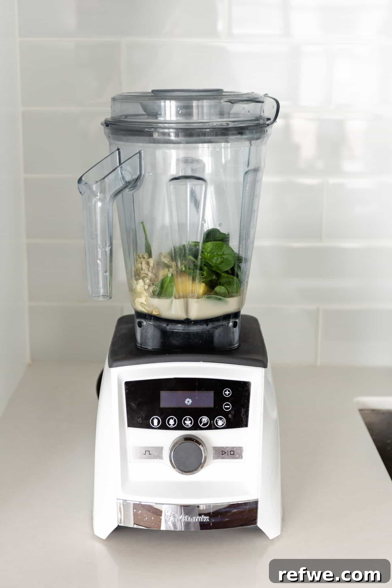 Supercharged Green Protein Smoothie 4 All the ingredients for the green protein smoothie, including almond milk, protein powder, spinach, pineapple, banana, and almond butter, neatly placed in a blender, ready for blending.