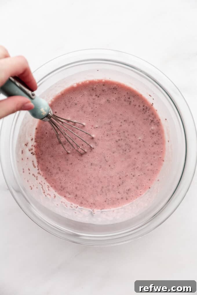 Strawberry Chia Delight 7 A whisk vigorously mixing strawberry milk and chia seeds in a bowl
