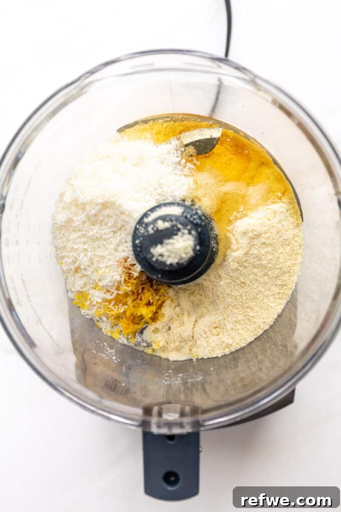Zesty Lemon Bites 4 Honey and fresh lemon juice being poured into the food processor with the dry ingredients, ready for blending.