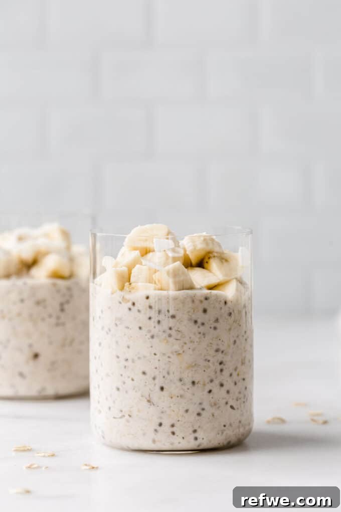 Creamy Banana Overnight Oats 9 Two appealing cups of banana overnight oats, beautifully topped with fresh banana slices, and a sprinkle of cinnamon, ready to be served and enjoyed as a healthy morning meal.