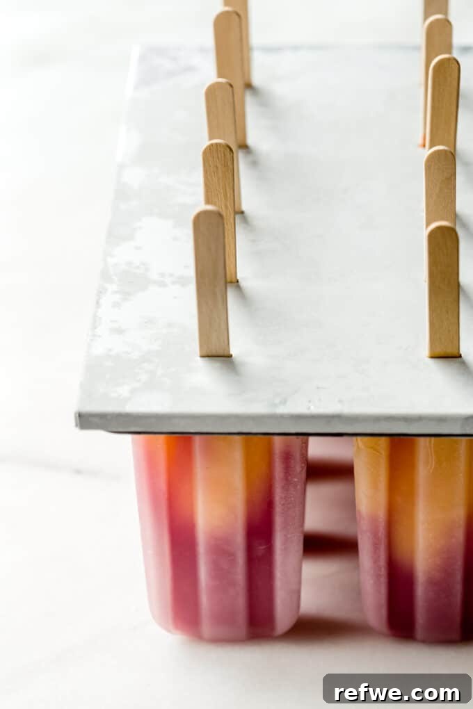 strawberry mango popsicles in a popsicle mold
