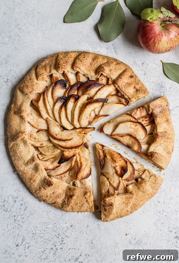 Savor the Season: 14 Fall Apple Recipes 13 Rustic Salted Caramel Apple Galette with beautifully arranged apple slices and a rich caramel drizzle, presented on a wooden surface.