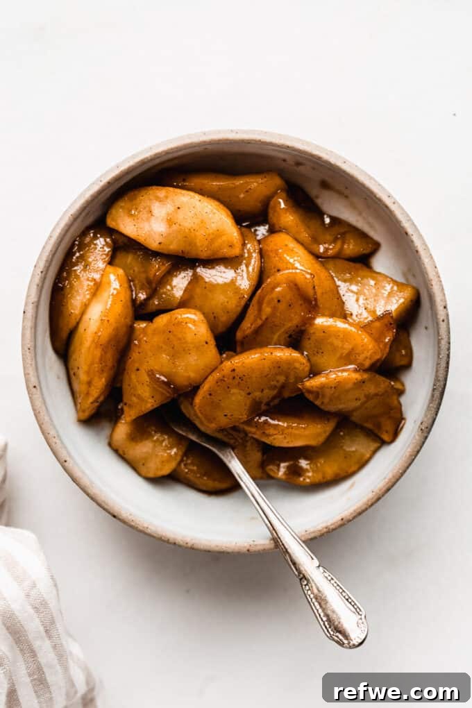 Savor the Season: 14 Fall Apple Recipes 8 Close-up of warm, glossy Skillet Cinnamon Apples, perfectly cooked and glistening, served in a cast-iron skillet.
