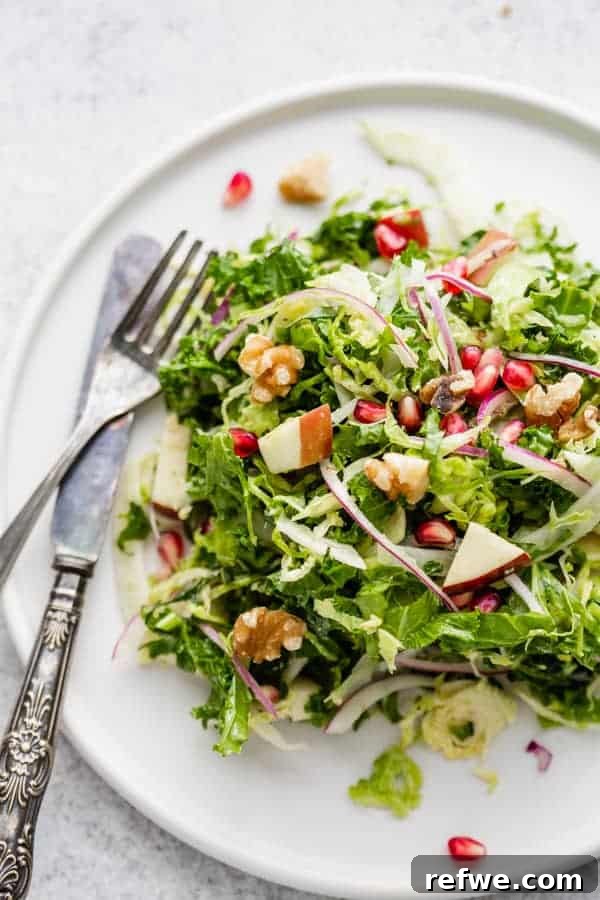 Savor the Season: 14 Fall Apple Recipes 9 A vibrant Shaved Brussels Sprouts, Fennel, and Apple Salad with a maple dijon dressing, presented in a large white serving bowl.