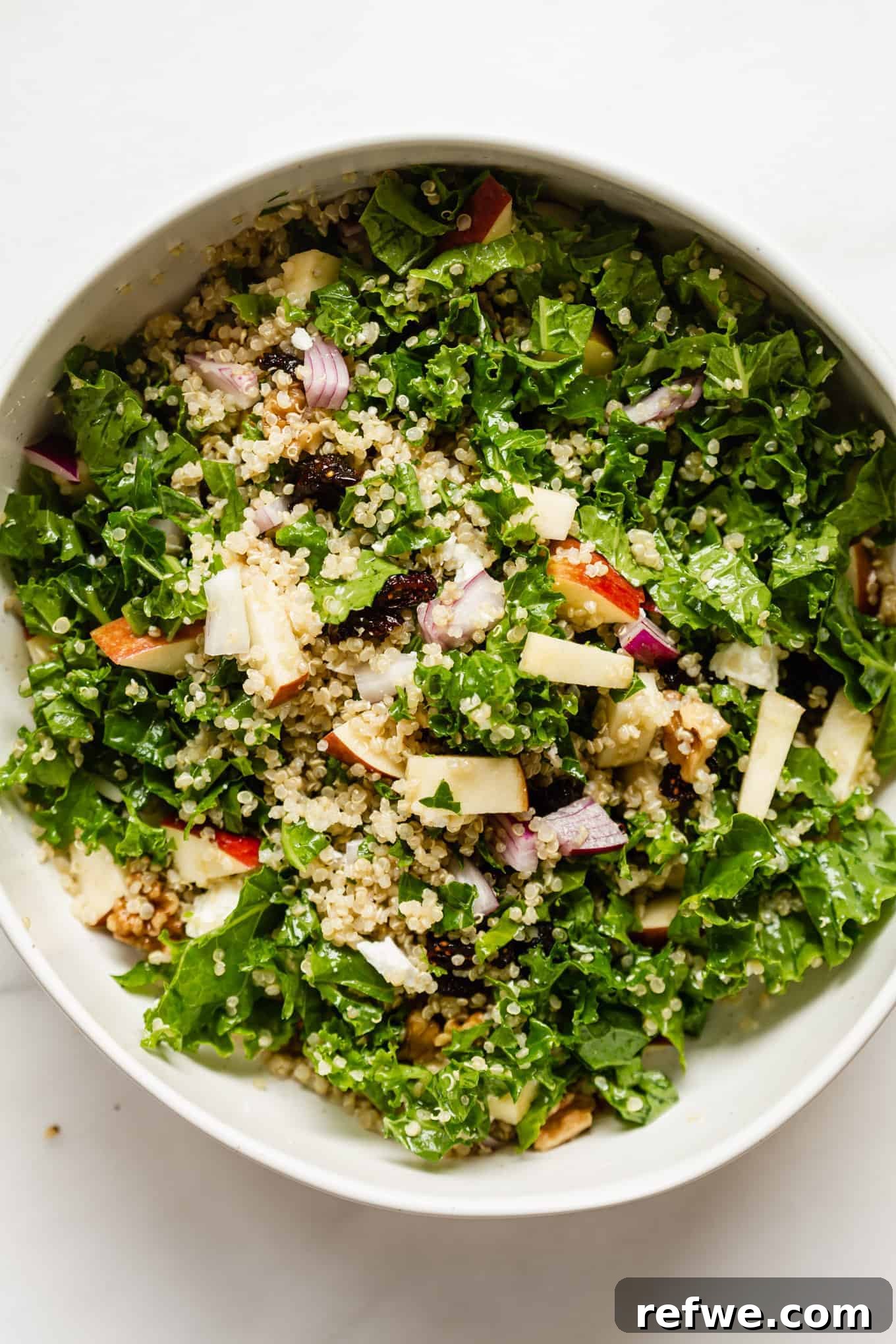 Vibrant Apple Cranberry Quinoa Salad 7 A large, inviting bowl of Apple Cranberry Quinoa Salad with fresh kale and apple slices visible, ready to be served.