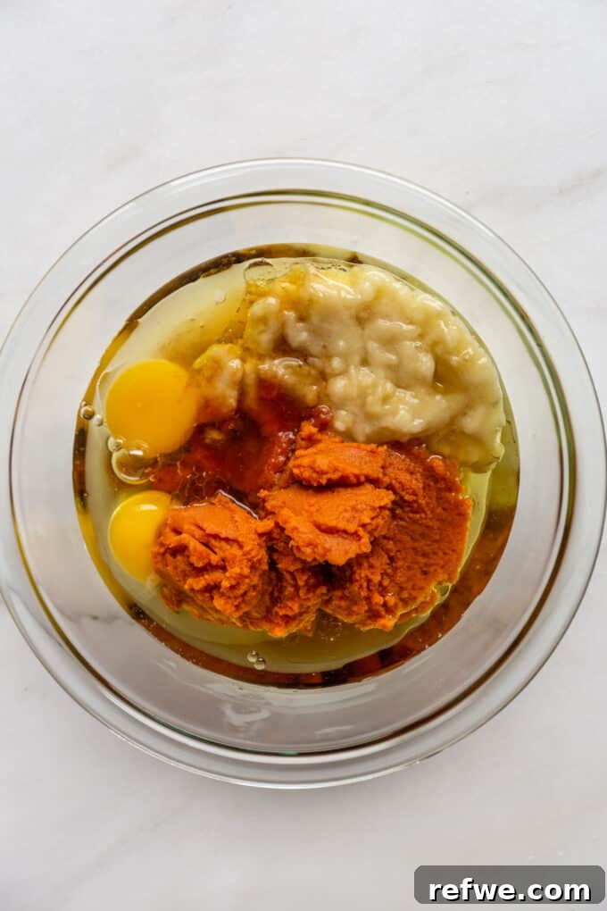Wholesome Pumpkin Banana Loaf 4 eggs, pumpkin puree, mashed banana and avocado oil in a mixing bowl