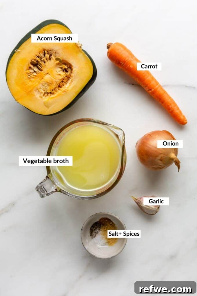 Roasted Autumn Acorn Bliss 3 A flat lay photograph showcasing all the fresh ingredients needed for roasted acorn squash soup, including whole acorn squash, onions, garlic, carrots, and spices.