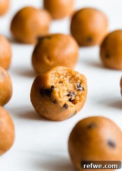 A pumpkin protein ball with a bite taken out of it, showcasing its delicious texture.