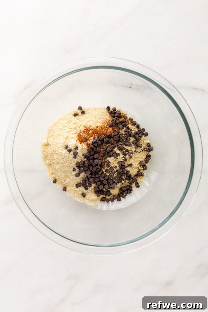Almond flour, protein powder, pumpkin pie spice, salt, and chocolate chips in a separate mixing bowl.