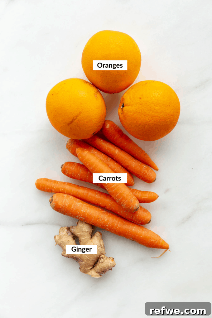 Zingy Ginger Carrot Orange Immunity Nectar 3 Fresh oranges, vibrant carrots, and a knob of ginger neatly arranged on a marble board, ready for juicing.