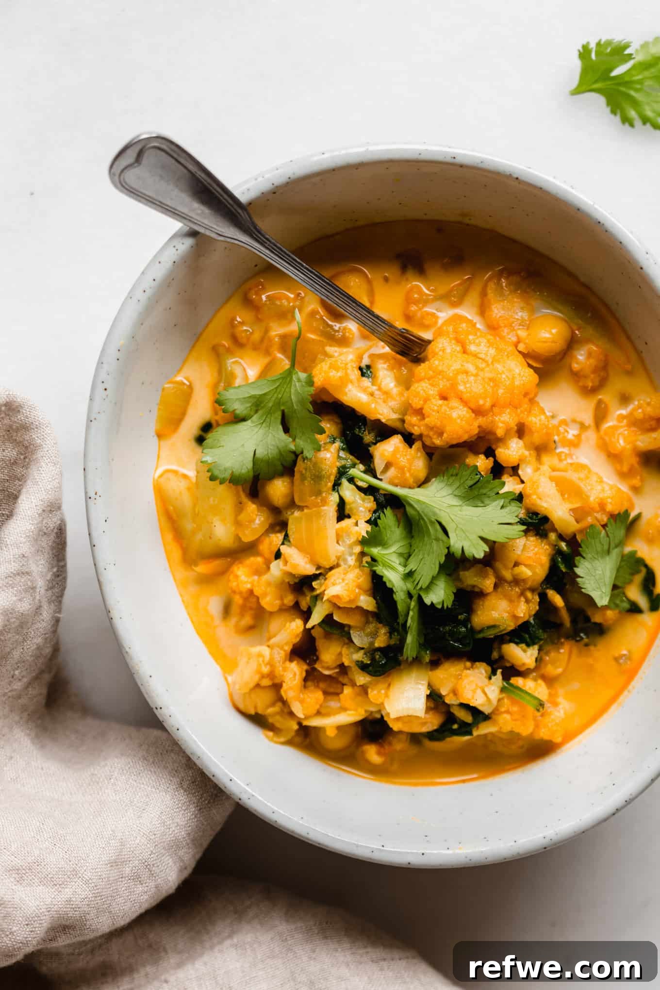 Golden Cauliflower Chickpea Curry 9 cauliflower curry in a bowl with a spoon