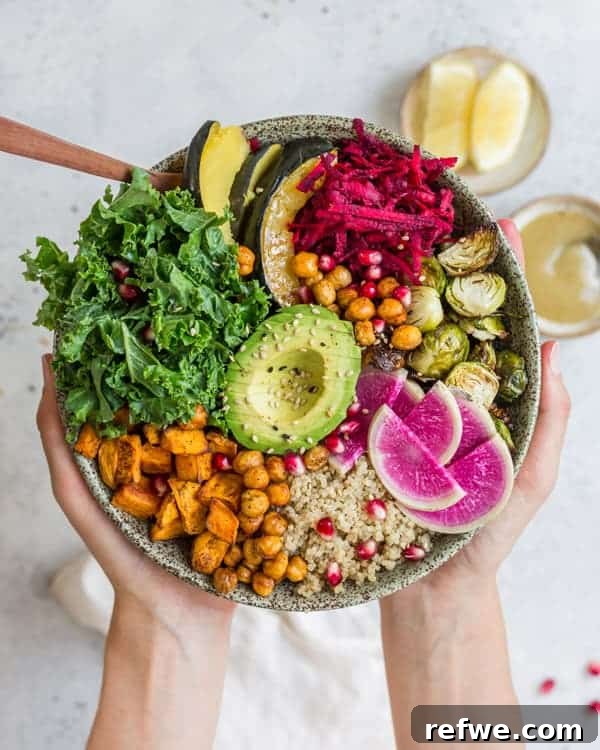A beautifully arranged Fall Harvest Buddha Bowl featuring roasted squash, brussels sprouts, chickpeas, sweet potato, quinoa, kale, and fresh toppings.