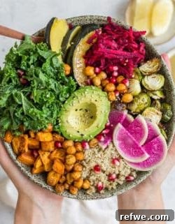 A vibrant Fall Harvest Buddha Bowl featuring roasted vegetables, chickpeas, quinoa, kale, and avocado.