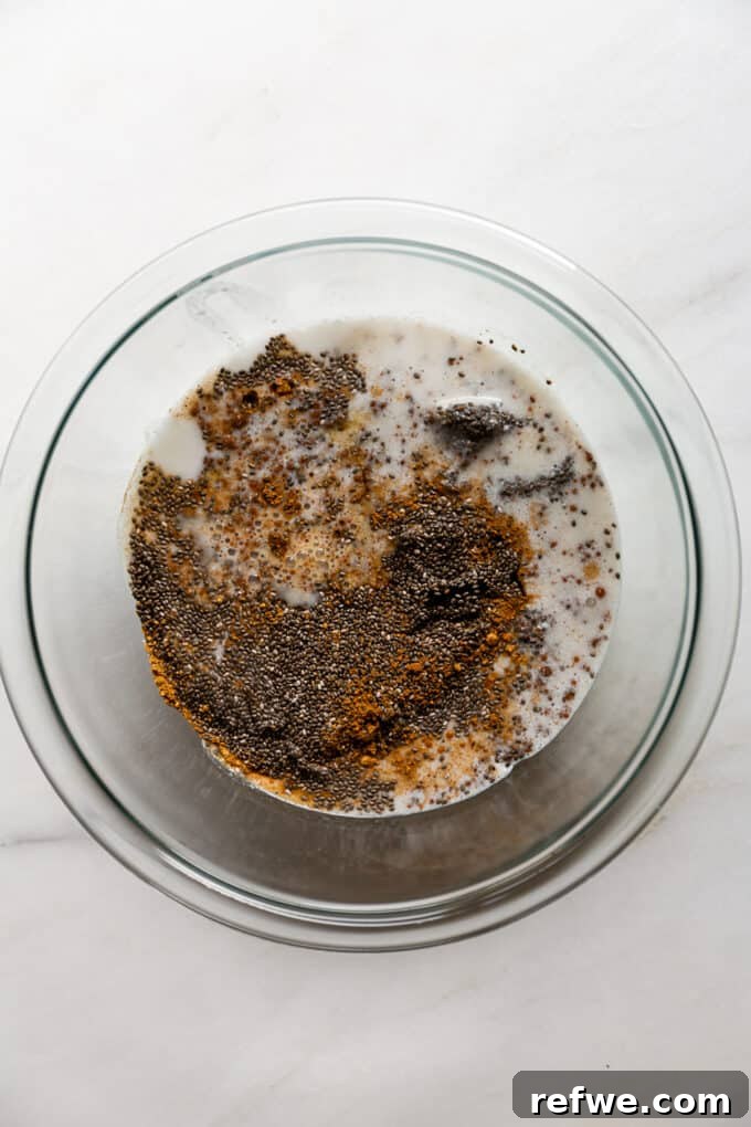 Gingerbread Spice Chia Delight 4 A clear mixing bowl holds chia seeds, creamy coconut milk, and a rich mixture of gingerbread spices, just before whisking.