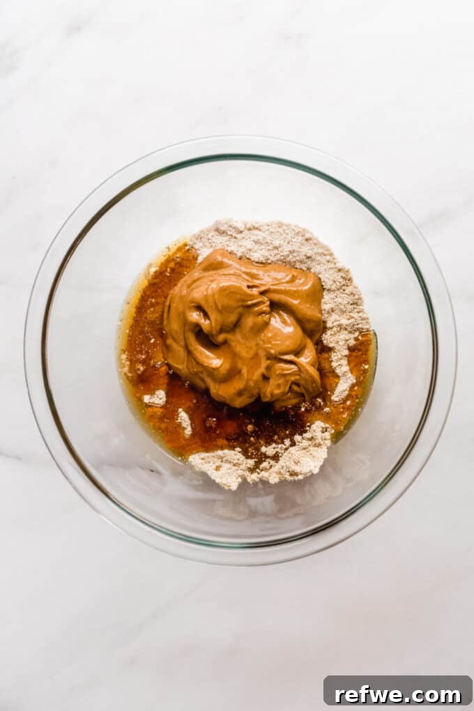 The Ultimate Homemade Snack Bars 5 Peanut butter, protein powder, almond flour and maple syrup in a mixing bowl