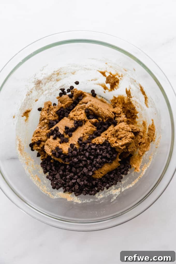 The Ultimate Homemade Snack Bars 7 Protein bar dough and chocolate chips in a mixing bowl, being mixed