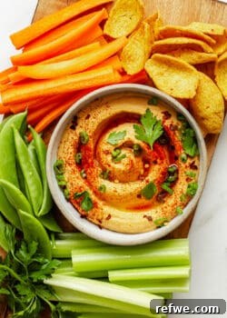 buffalo hummus on a wood board with vegetables and chips