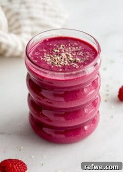 A vibrant glass of Berry Beet Smoothie, garnished, with a napkin in the background, ready to be enjoyed.